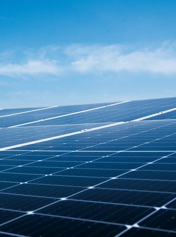 Solarmodule einer Photovoltaikanlage auf einer Dachfläche unter blauem Himmel.