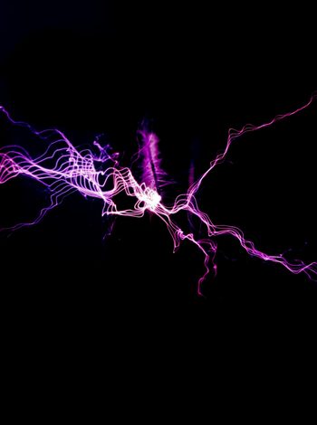 Abstrakte elektrische Entladung mit pinken und violetten Lichtspuren auf schwarzem Hintergrund.